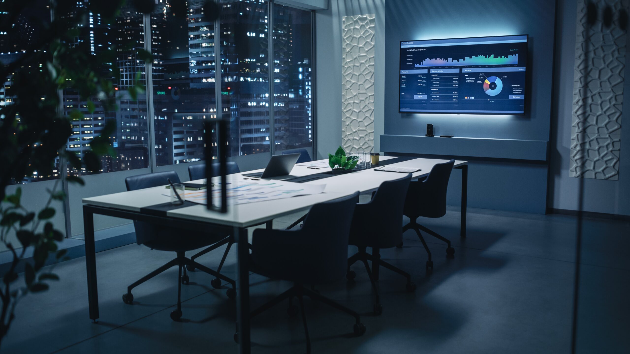 A conference room featuring a large screen at the front and several chairs arranged for attendees.
